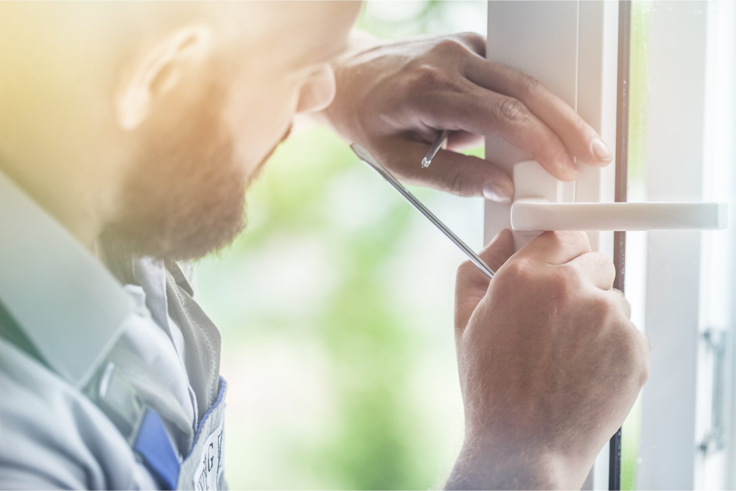 Door. Image of a man using a screwdriver to fix a door with screws, ensuring prevention of unintended lockouts.