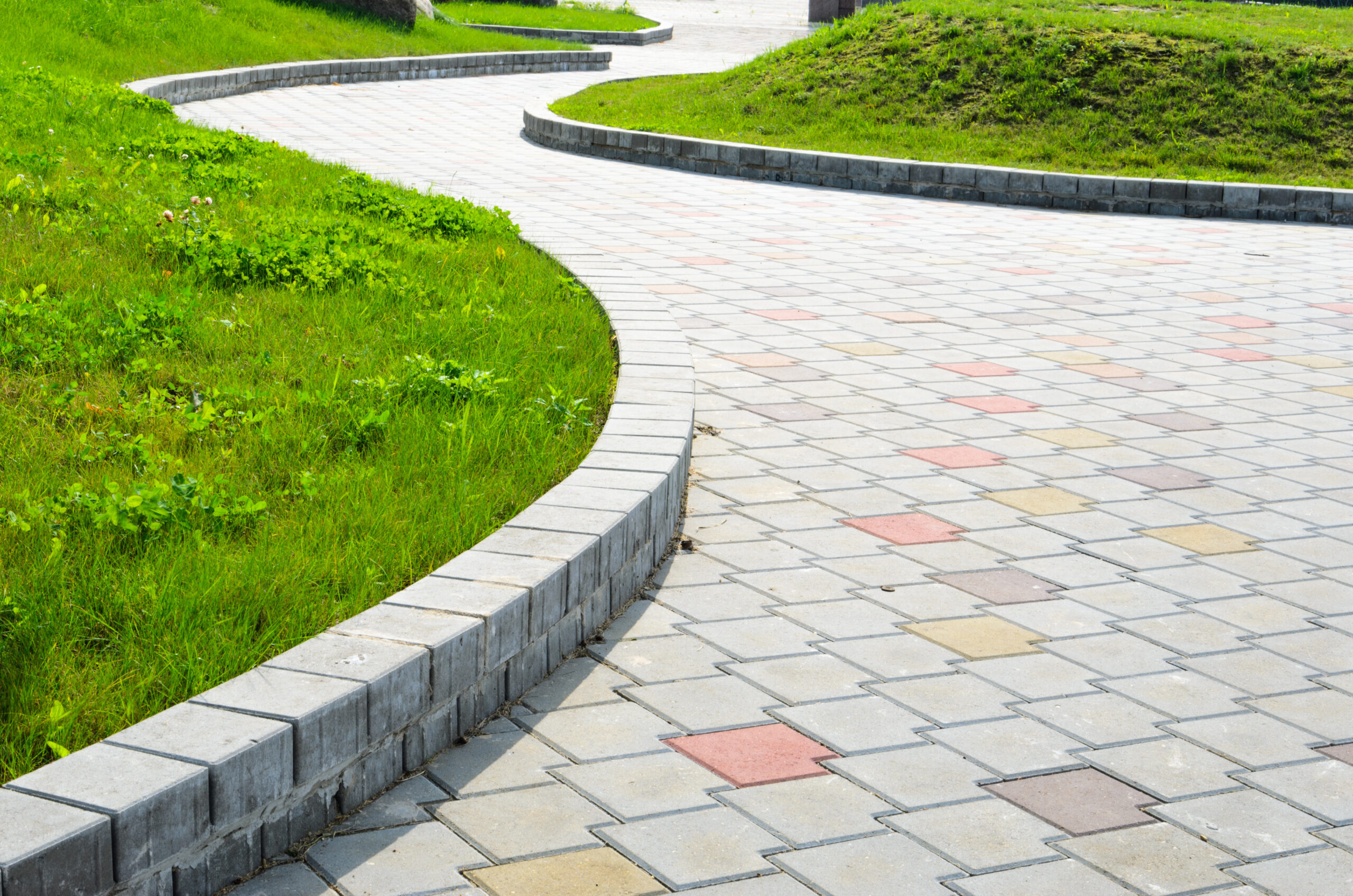 Curved garden path featuring a variety of multicolored sidewalk tiles creating a vibrant and visually appealing walkway through the lush greenery. Curved garden path featuring a variety of multicolored sidewalk tiles creating a vibrant and visually appealing walkway through the lush greenery.